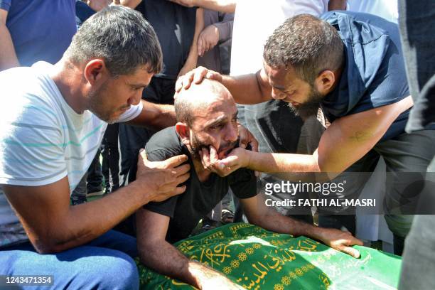 Mourners react by the body of one of the victims who drowned in the shipwreck of a migrant boat that sank off the Syrian coast, during his funeral...