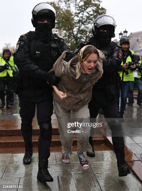 Police officers detain a woman in Moscow on September 24 following calls to protest against the partial mobilisation announced by the Russian...