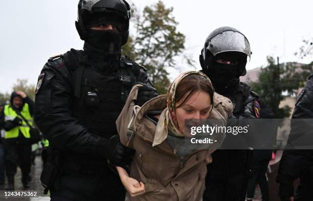 Police officers detain a woman in Moscow on September 24 following calls to protest against the partial mobilisation announced by the Russian...