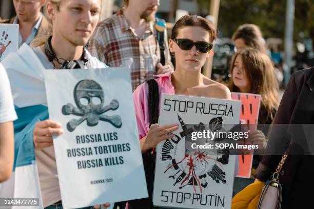 Female protester holds a placard that says "Stop Russia, Stop Putin" during an anti-war and anti-referendum protest against the Russian invasion of...