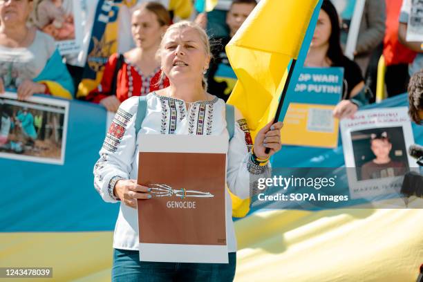 Ukrainian woman holds a placard that says "Genocide" during an anti-war and anti-referendum protest against the Russian invasion of Ukraine. After...