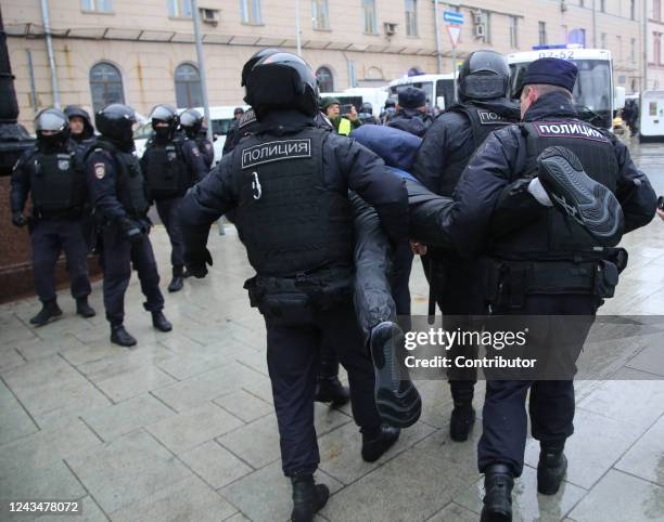 Police officers detain a protester during the unsanctioned rally hosted by the Vesna Movement in protest against the military invasion on Ukraine and...