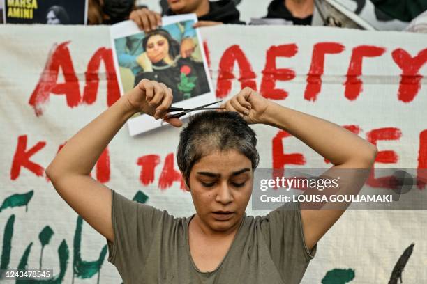 Eli, an Iranian refugee woman living in Greece cuts her hair during a demonstration by Iranians living in Greece in central Athens on September 24...