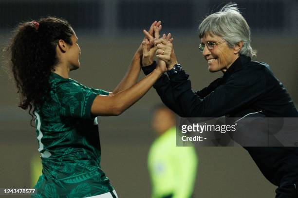 Saudi Arabia's Bayan Sadagah celebrates her goal with her coach Monika Staab during a friendly football match between Saudi Arabia and Bhutan at...