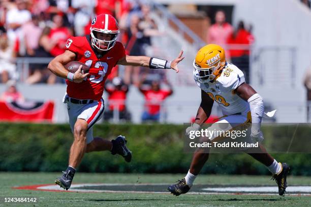 Stetson Bennett of the Georgia Bulldogs stiff arms Marvin Pierre of the Kent State Golden Flashes in the first half at Sanford Stadium on September...