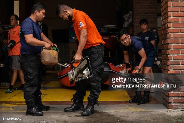 Members of the Disaster Risk Reduction and Management Office prepare rubber boats and life vests ahead of Super Typhoon Noru making landfall, at...