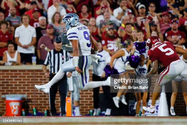 Quarterback Adrian Martinez of the Kansas State Wildcats scores a 15-yard touchdown against defensive back Billy Bowman Jr. #5 of the Oklahoma...