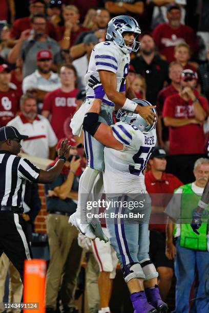 Quarterback Adrian Martinez of the Kansas State Wildcats celebrates his 15-yard touchdown in the arms of left guard Cooper Beebe against the Oklahoma...