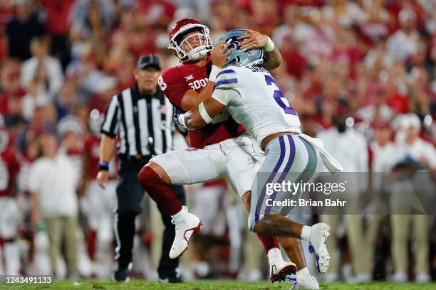 Quarterback Dillon Gabriel of the Oklahoma Sooners gets hit by Kobe Savage of the Kansas State Wildcats on a one-yard touchdown pass in the fourth...