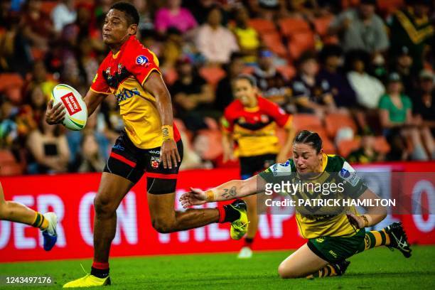 Papua New Guinea's Joanne Lagona beats the tackle of Australia's Stephanie Hancock during the international women's rugby league match between...