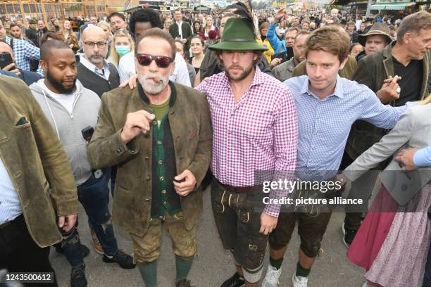 September 2022, Bavaria, Munich: Actor Arnold Schwarzenegger walks across the Theresienwiese with his sons Christopher Schwarzenegger and Patrick...