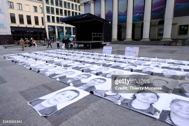 Activists display photos of Uyghurs outside the Place de la Monnaie on September 25, 2022 in Brussels, Belgium.