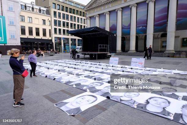 Activists display photos of Uyghurs outside the Place de la Monnaie on September 25, 2022 in Brussels, Belgium.