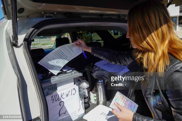 Woman casts her ballot for a referendum at a mobile voting station in Mariupol on September 25, 2022. - Western nations dismissed the referendums in...
