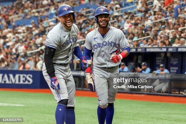 George Springer of the Toronto Blue Jays celebrates his home run against the Tampa Bay Rays with Raimel Tapia in the third inning during a baseball...