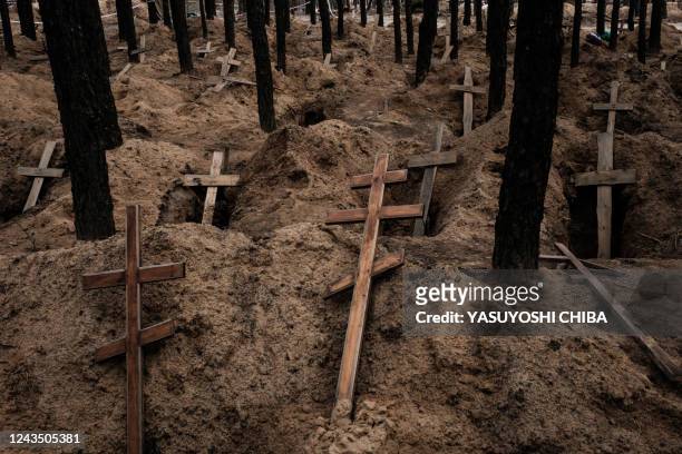 This photograph taken on September 25 shows empty graves after exhumation of bodies in the mass grave created during the Russian's occupation in...
