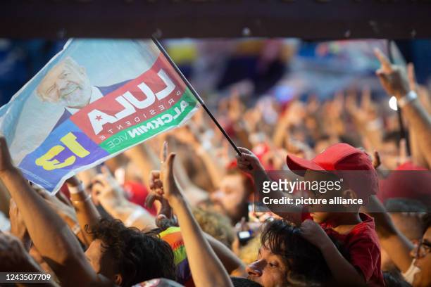 September 2022, Brazil, Rio de Janeiro: A boy holds the flag with the photo of the presidential candidate of the Brazilian Workers' Party ,...