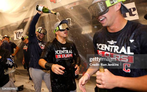 Steven Kwan of the Cleveland Guardians celebrates with teammates after defeating the Texas Rangers 10-4 and clinching the American League Central...