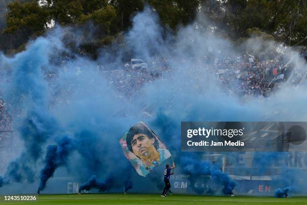 Fan of Gimnasia waves a flag of late football legend Diego Maradona prior a match between Gimnasia and Tigres as part of Liga Profesional 2022 at...