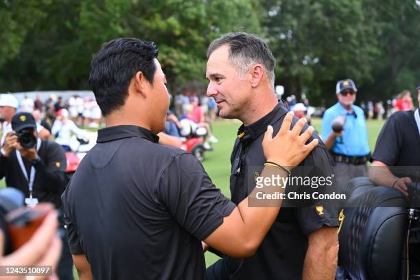 International Team player Tom Kim of South Korea is seen talking with Captian Trevor Immelman of South Africa during the final round Sunday singles...