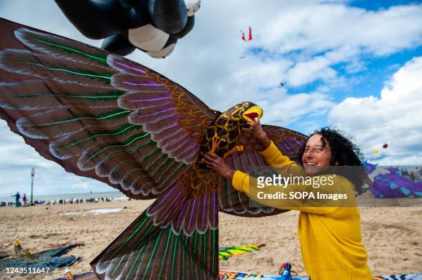 Woman poses with one of her hand made kites in the shape of a bird. The International Kite Festival Scheveningen makes the most of the consistent...