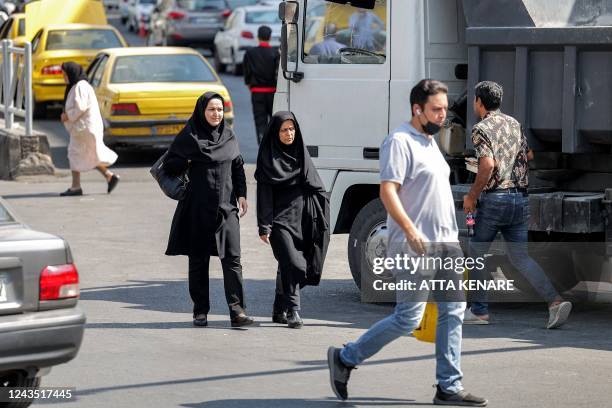 Women walk along a street in the centre of Iran's capital Tehran on September 26, 2022.