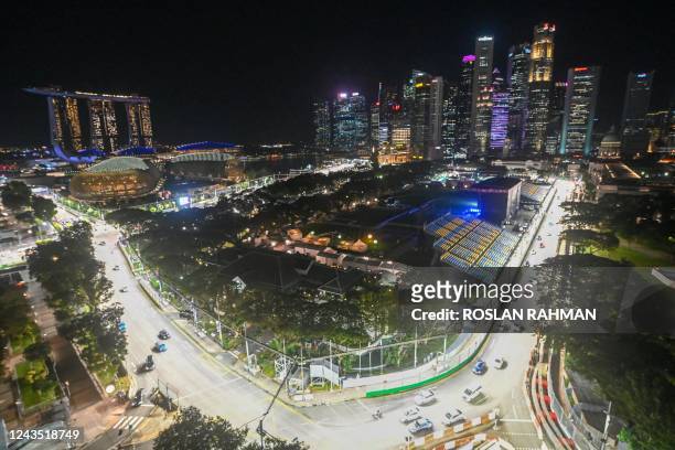 Cars drive on the illuminated race track for the upcoming Formula One Singapore Grand Prix night race at the Marina Bay Street Circuit in Singapore...