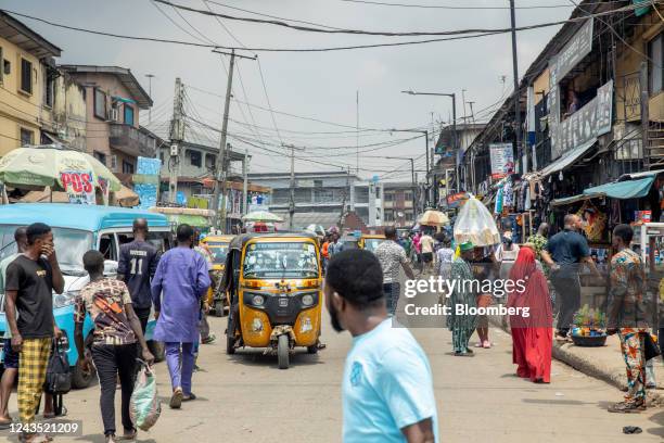 Pedestrians and auto-rickshaws make their way down a street in Lagos, Nigeria, on Saturday, Sept. 24, 2022. Nigeria's inflation rate hit a fresh...