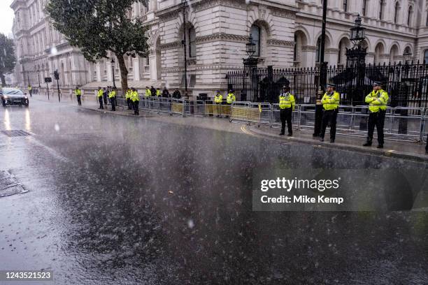 Metropolitan Police on duty as torrential rain pours down in Westminster as Liz Truss, winner of the Conservative Party leadership race is about to...