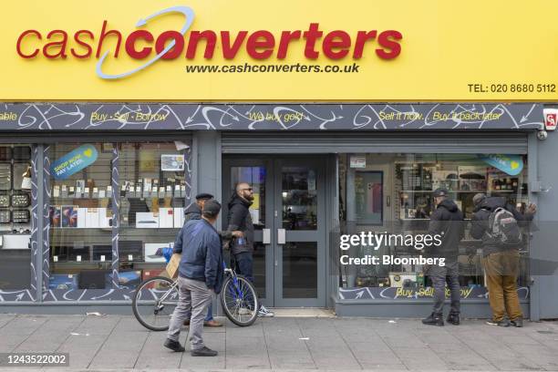 Customers wait outside a Cash Converters pawn brokers before it opens in Croydon, Greater London, UK on Monday, Sept. 26, 2022. The Bank of England...
