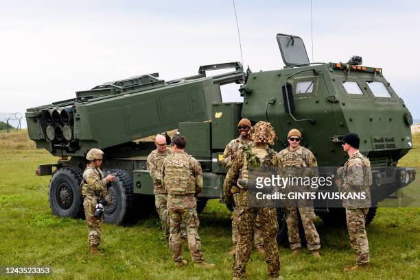Military personnel stands in front of a High Mobility Artillery Rocket Systems during the military exercise Namejs 2022 on September 26, 2022 in...