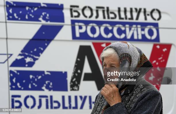 An elderly woman walks as people cast their votes in controversial referendums in Mariupol, Donetsk Oblast, Ukraine on September 26, 2022. Voting...
