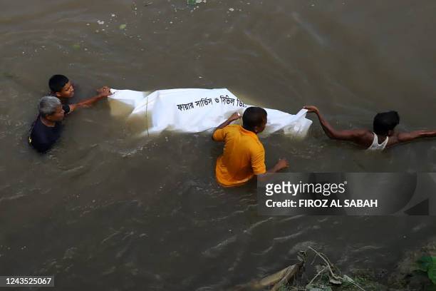 Graphic content / TOPSHOT - People pull the dead body of a victim who died after a boat capsized in river Karotoa near Boda town on September 26,...
