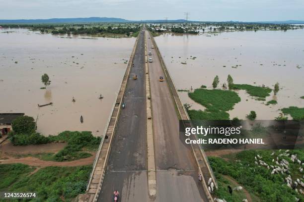 This aerial view shows local residents crossing the Numan bridge while driving to a safer grounds on September 25, 2022 away from the rising waters...