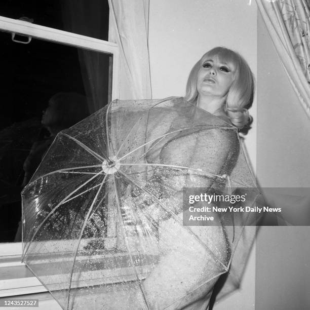 November 29: Topless dancer Carol Doda covers up with an umbrella while meeting the press. November, 1966.