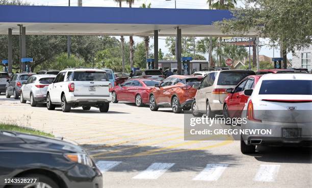 Motorists wait in long lines to fill their vehicles with gas ahead of the oncoming storm in Kissimmee, Florida, on September 26, 2022. - Tropical...