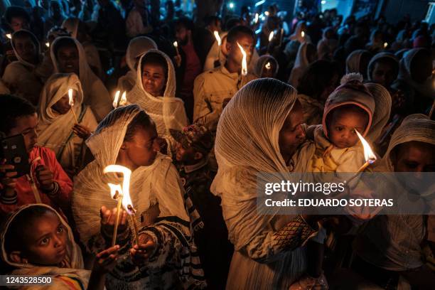 Orthodox devotees hold candles during the celebrations on the eve of the Ethiopian Orthodox holiday of Meskel, that commemorates the discovery in the...