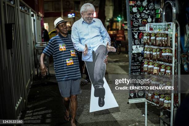 Supporter of Brazilian former President and presidential candidate for the leftist workers party Luiz Inacio Lula da Silva holds a cardboard cut-out...