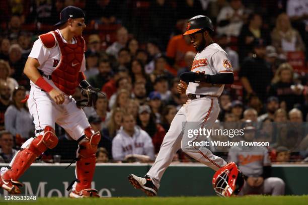 Cedric Mullins of the Baltimore Orioles scores as catcher Reese McGuire of the Boston Red Sox awaits the throw in the second inning at Fenway Park on...