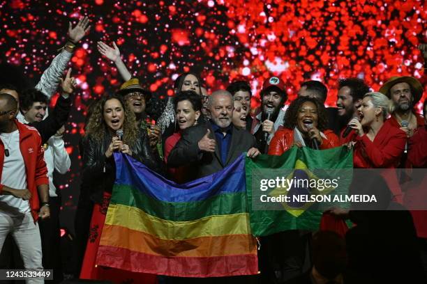 Brazilian former President and presidential candidate for the leftist Workers Party Luiz Inacio Lula da Silva holds both a Brazilian and a rainbow...