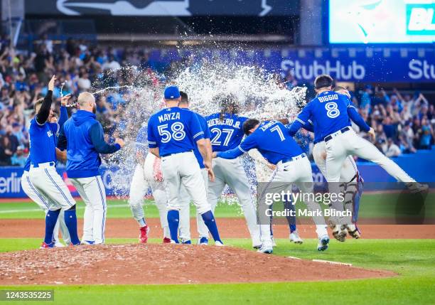 Teammates splash Vladimir Guerrero Jr. #27 of the Toronto Blue Jays with water after his walk-off hit to defeat the New York Yankees in the tenth...