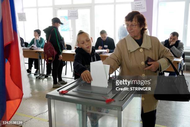Woman casts her ballot for a referendum at a polling station in Mariupol on September 27, 2022. - Western nations dismissed the referendums in...