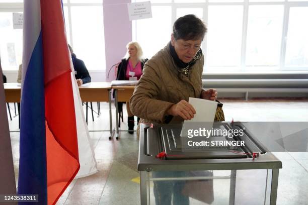 Woman casts her ballot for a referendum at a polling station in Mariupol on September 27, 2022. - Western nations dismissed the referendums in...