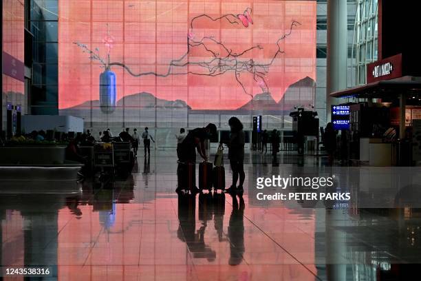 Travellers arrive at Hong Kong's international airport on September 27, 2022. - Hong Kong on September 26 ended mandatory hotel quarantine, scrapping...