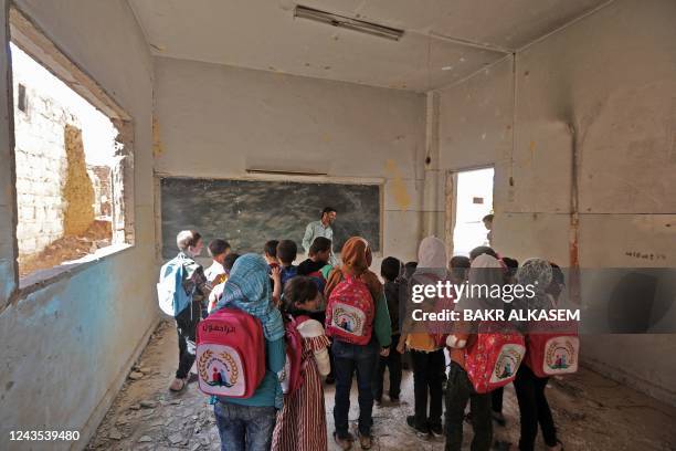 Syrian school children stand in a classroom in a makeshift school in the rebel-held side of the divided northern town of Tadif, located about 32...