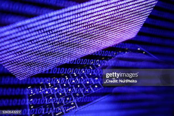 Binary code displayed on a laptop screen and binary code displayed on a screen are seen in this multiple exposure illustration photo taken in Krakow,...