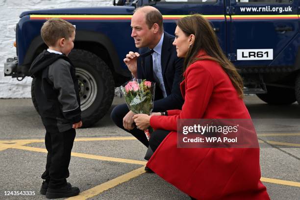 Prince William, Prince of Wales gestures as his wife Catherine, Princess of Wales is presented with a posy of flowers by four-year-old Theo Crompton...