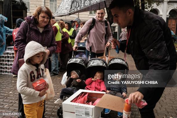 Ilyuashenko Tatyana , 32-year-old mother of four, receives food items during its distribution to about 3000 people by the local branch of Caritas...