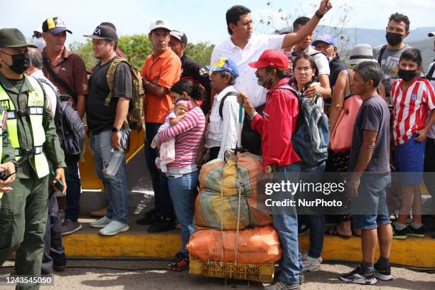 People carrying packages are seen crossing through the Simon Bolivar International Bridge, during the official reopening ceremony of the border...