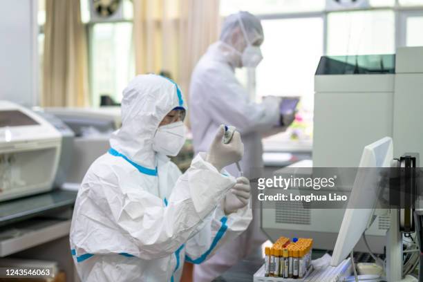 two asian male doctors do tests in the laboratory - covid-19 china stock pictures, royalty-free photos & images